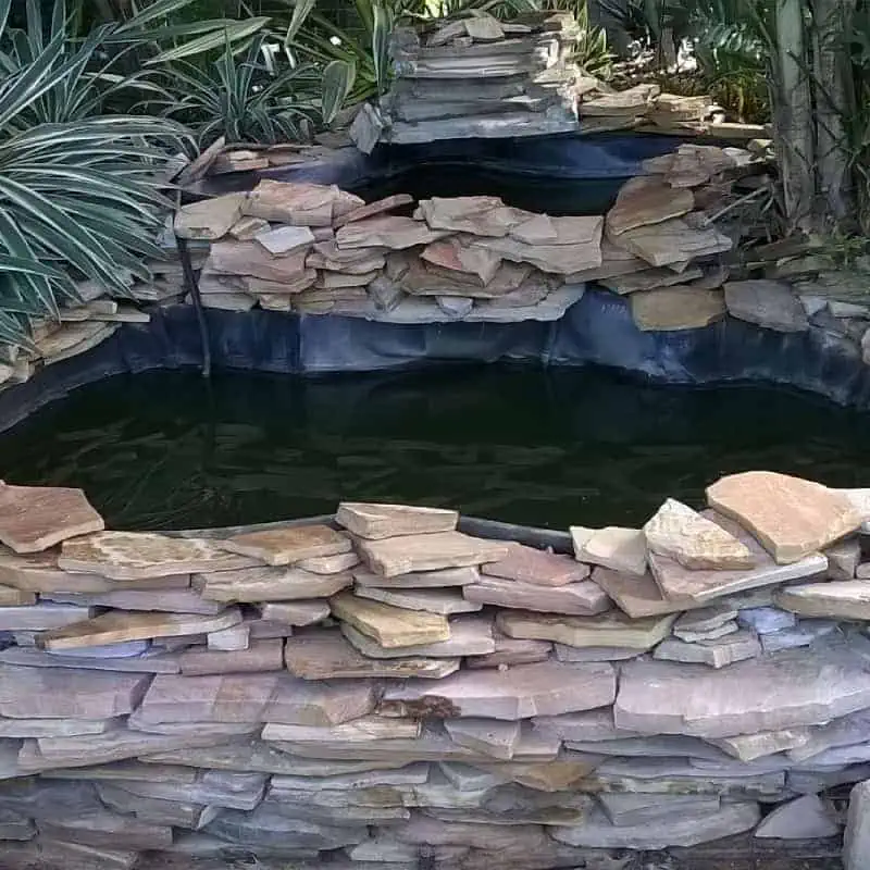 Small raised pond with stone slabs