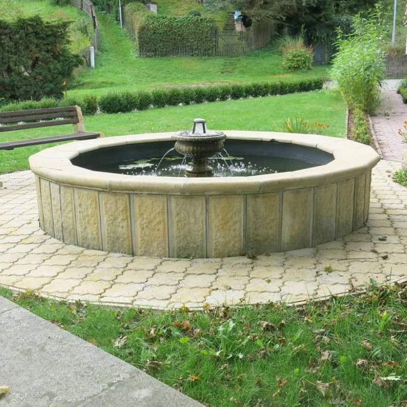 Raised circular pond with fountain