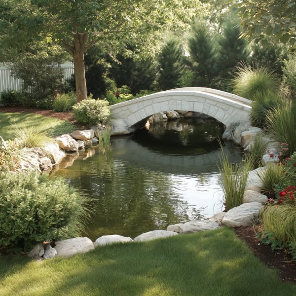 Arched white stone pond bridge