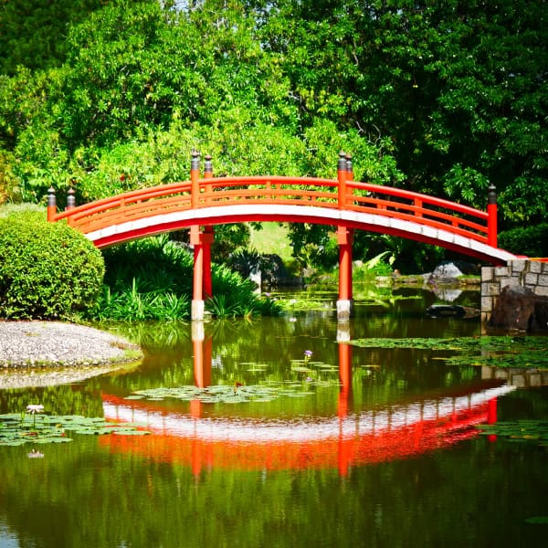 Curved red lacquer pond bridge